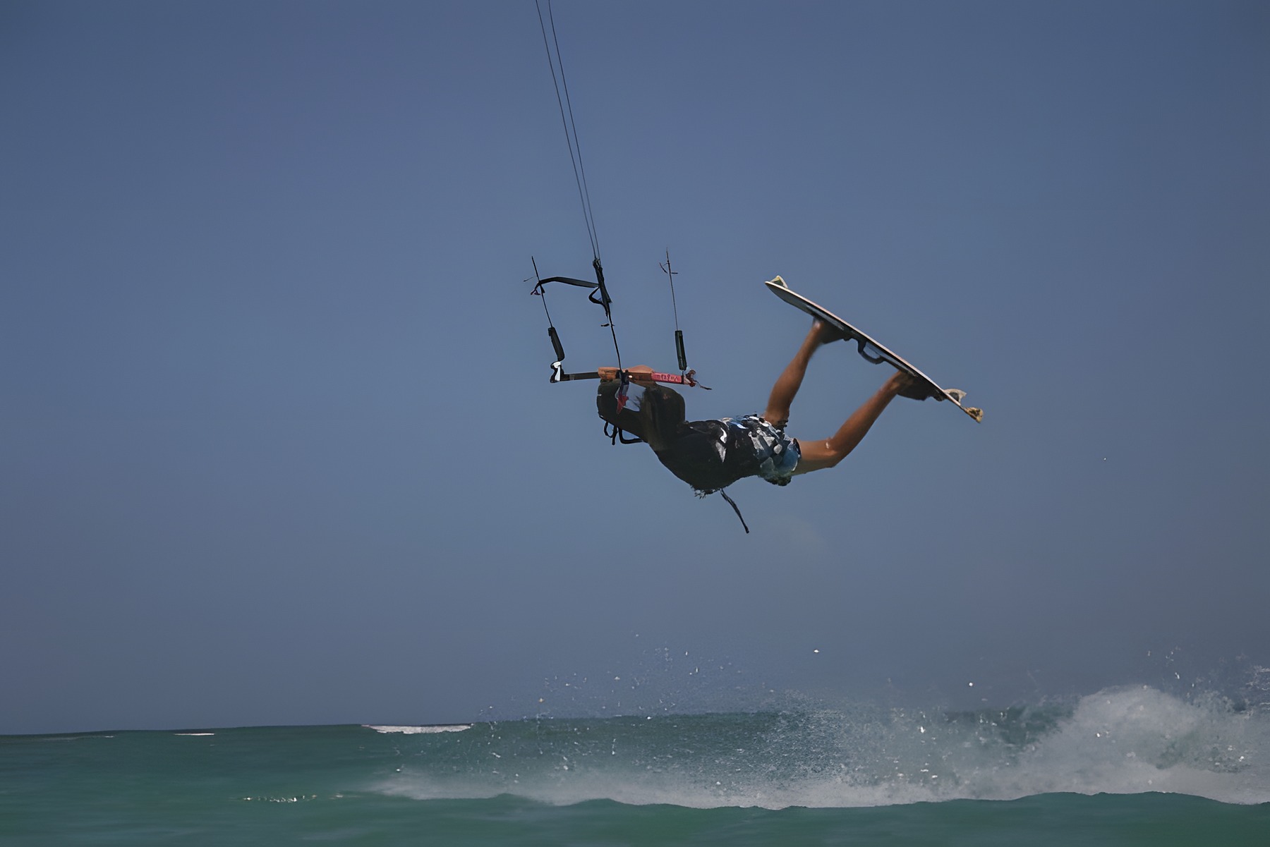 Teenage Hugo Beaumont upside down mid-trick on a kiteboard